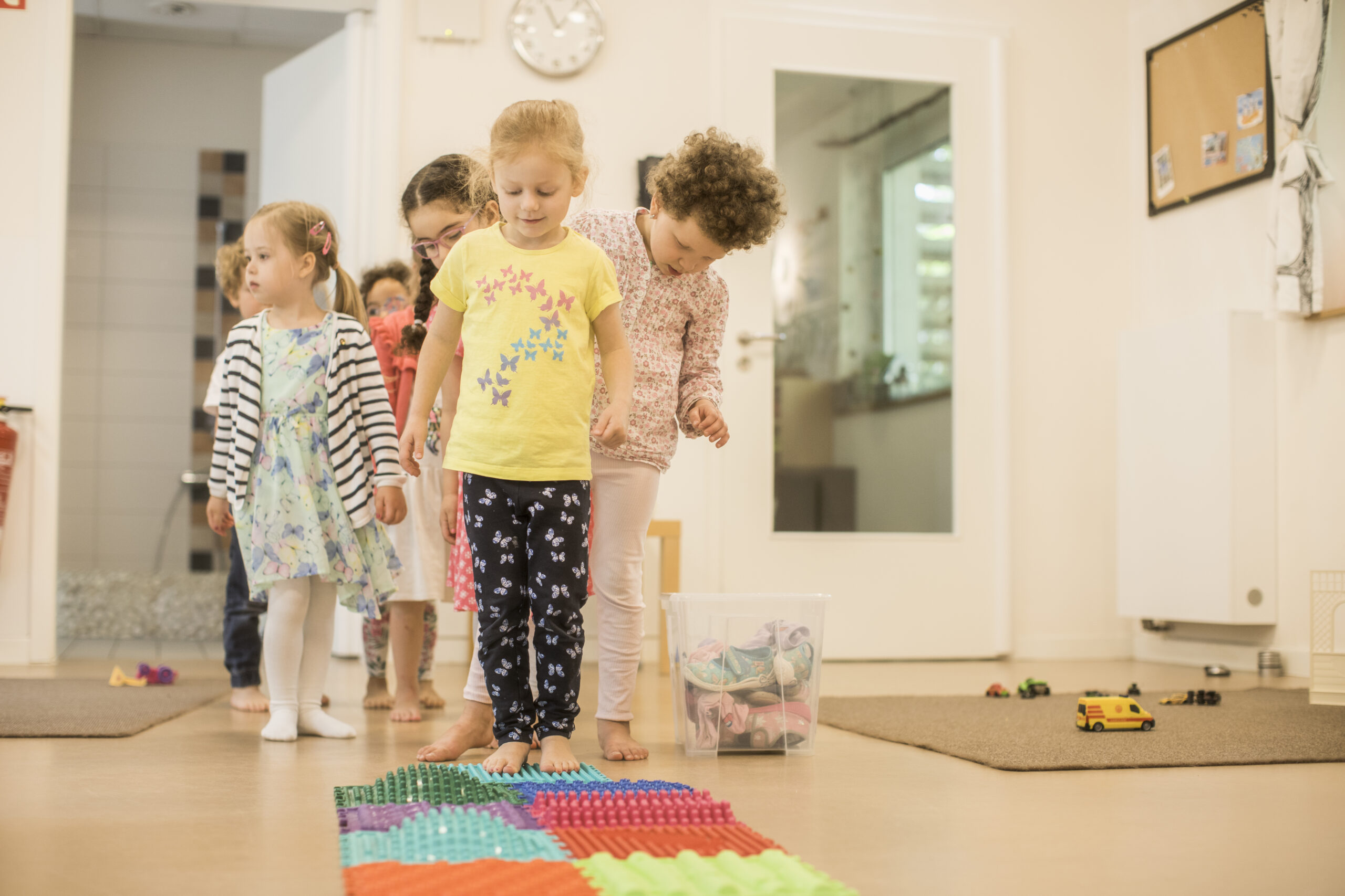 Kinder in einer KiTa in Hamburg - Harburg vor einem Teppich aus Plastikteilen